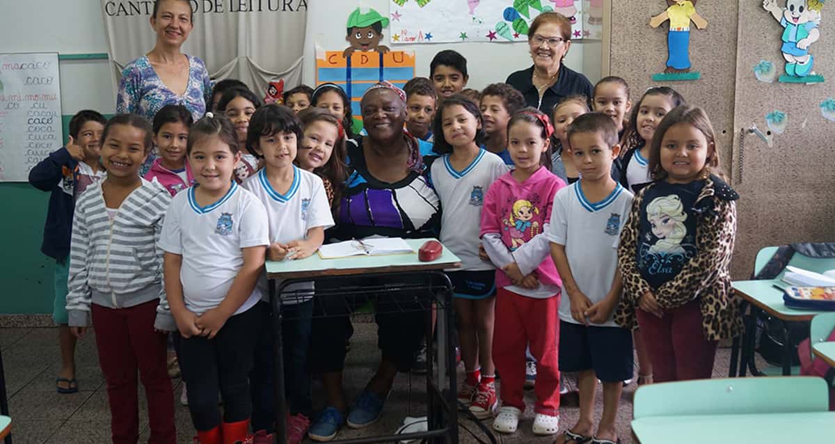 Senhora de 65 anos é acolhida por crianças para aprender a ler