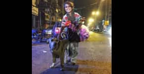 Sem ter o que calçar, menino agasalha cão de rua e foto viraliza