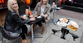 Robô voador entrega comida na mesa em restaurante