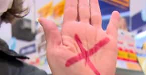Mulher pede socorro mostrando ‘X vermelho’ na mão em farmácia