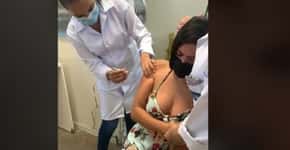 Com medo, jovem é abraçada por enfermeira ao receber vacina contra covid
