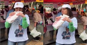 Rosangela Moro come pastel enquanto mulher revira lixo