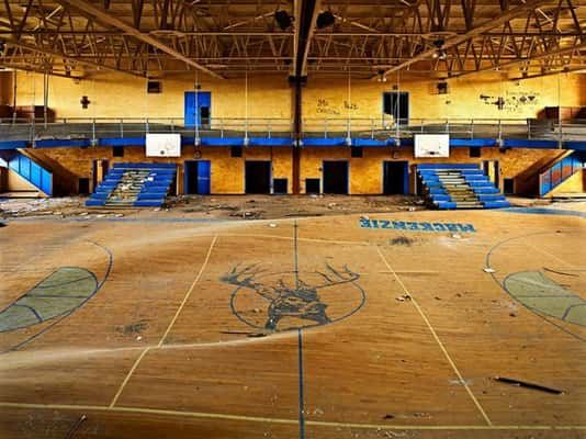 Um ginásio de escola, em Detroit, com piso deformados pela pressão da água. [Michigan, EUA]