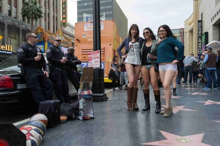 Mulheres sem calças em Hollywood sendo observadas por policiais durante o evento No Pants Metro Ride.