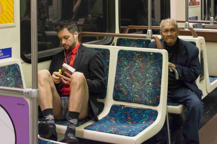 Homem sem calças ouvindo musica no metrô durante o evento No Pants Metro Ride, em Los Angeles.