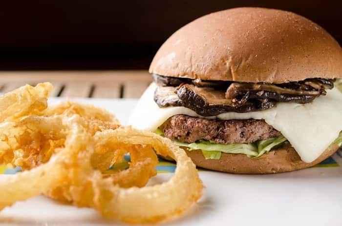 Bibi Sucos - Netuno: 200g de hamburger de fraldinha, com shitake salteado no gengibre e shoyo, mussarela de búfala gratinada, servido no pão australiano e acompanhado de anéis de cebola (R$ 29,50)