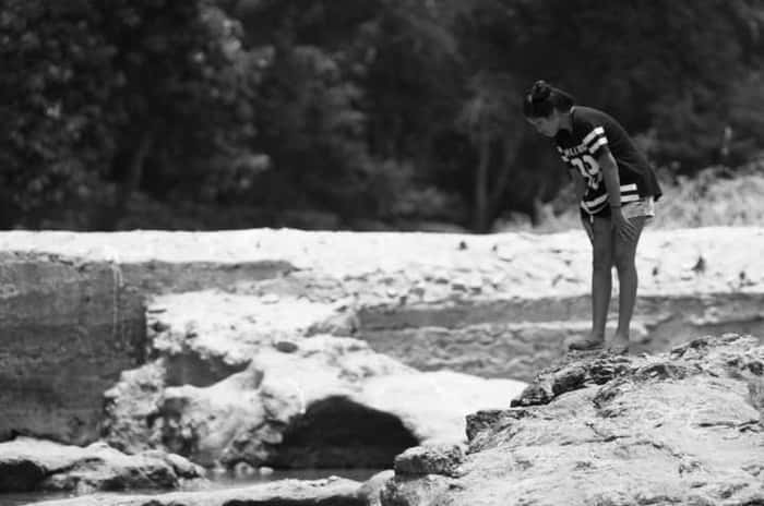 Amanda, de 22 anos, passou a infância e a adolescência nadando no rio Doce. Na imagem, a jovem observa o rio Eme, um dos afluentes do Doce, que também foi afetado pela lama tóxica
