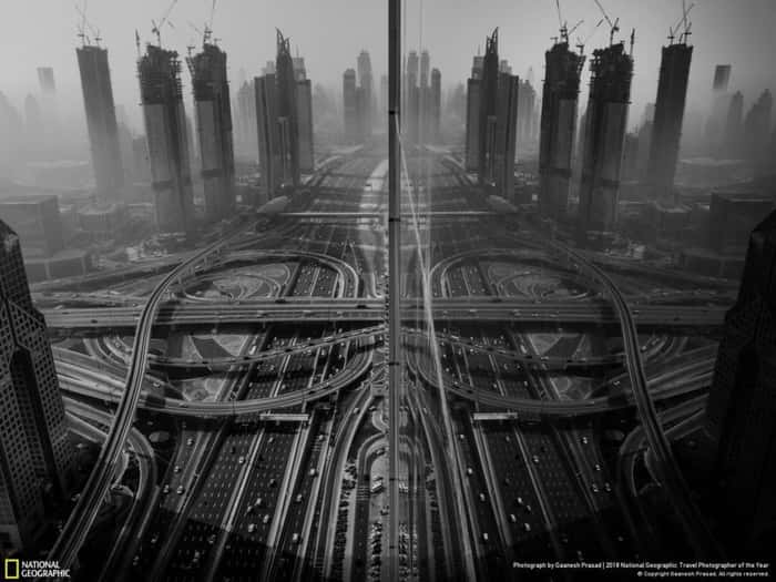 Imgem mostra edifícios parcialmente encobertos pela neblina e refletidos na fachada de um prédio no centro de Dubai, nos Emirados Árabes; foto conquistou terceiro lugar na categoria Cidades