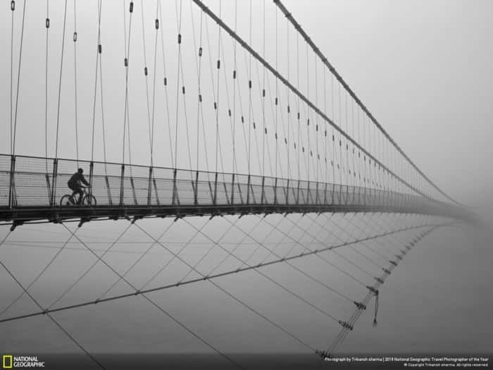 Ciclista cruza ponte Ram Jhula em Rishikesh, na Índia; imagem foi a mais votada pelo público na categoria Cidades