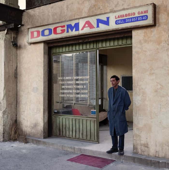 Homem parado em frente a uma loja chamada Dogman