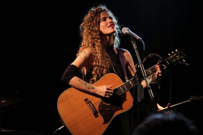 Ana Cañas tocando violão no palco
