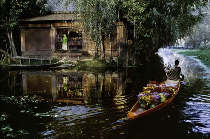Vendedor de flores navegando em bote no rio