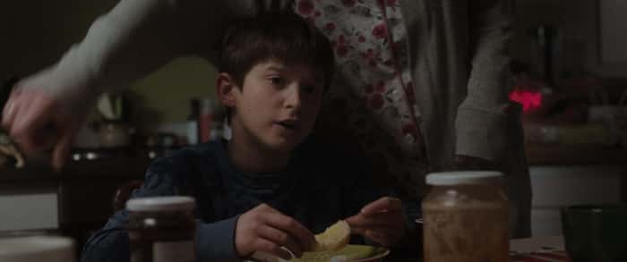 Criança sentada na mesma comendo