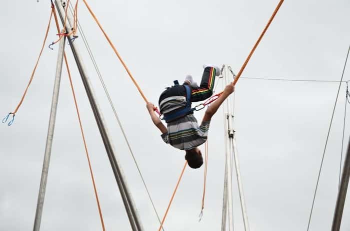garoto fazendo acrobacias no bungee trampolim