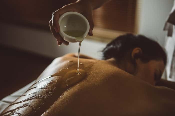 massagem corporal à base de hidratante e óleo