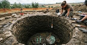 Arqueólogos chegaram ao fundo de um poço de 2.500 anos e encontraram dois esqueletos ao lado de misteriosas oferendas de bronze