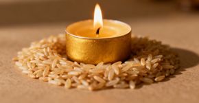Ritual simples com vela dourada e arroz cru para atrair dinheiro