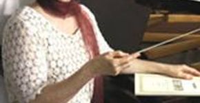 Muriel Waldman rege orquestra e coral apresentando obra de Rheinberger