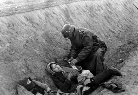 Um soldado alemão faz um curativo em um civil russo ferido. [II Guerra Mundial, c. 1941]