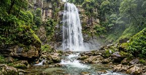 Mais de 200 quilômetros de trilhas atravessam florestas e levam a cachoeiras escondidas: o parque fluminense de 19.855 hectares onde a Cachoeira Véu da Noiva cai entre as montanhas da Serra dos Órgãos.
