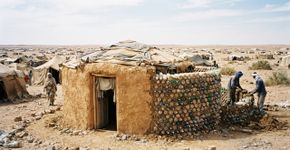 Em 2016, um engenheiro refugiado encheu garrafas descartadas com areia para construir uma casa mais segura para a avó no deserto; a experiência acabou virando 25 casas