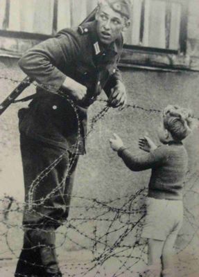 Um soldado da Alemanha Oriental ignora ordens para não deixar ninguém passar e ajuda a um menino, que foi encontrado no lado oposto de sua família, a atravessar o 