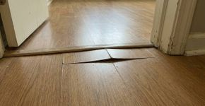 Piso laminado começa a levantar perto da porta meses depois da instalação, e a falta de espaço para dilatação pode empurrar as réguas quando o ambiente muda