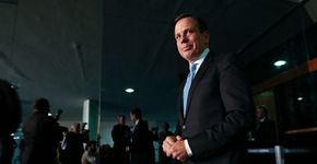 Prefeito Doria joga no chão flores que recebeu de uma ciclista