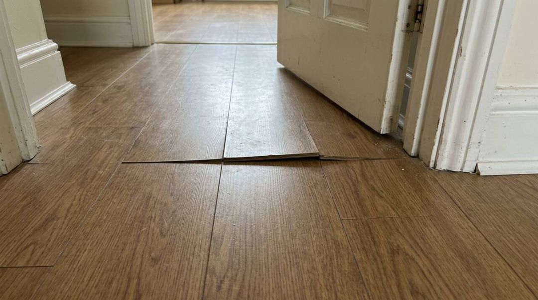 As réguas do piso laminado começaram a levantar? Entenda o papel da folga perimetral, dos batentes e rodapés e saiba o que observar antes do reparo.