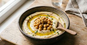 Grão-de-bico triturado com temperos e azeite: a mistura transforma uma leguminosa comum em uma pasta cremosa rica em fibras e uma alternativa prática para acompanhar pães e torradas