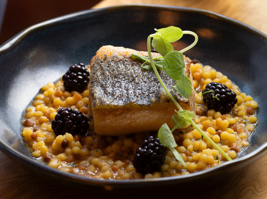 Robalo Grelhado, acompanhado de fregola cozida no caldo de peixe assado, picles de amora e rosas