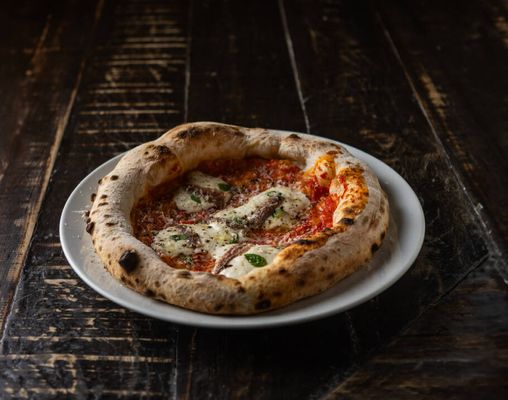 Bia Limoni misturou tomates San Marzano, alici e parmesão com a leveza da stracciatella e a fragrância da manjerona.