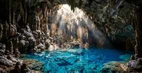 Quase 300 degraus descem por cerca de 60 metros até revelar um lago subterrâneo de azul intenso: a gruta de Bonito onde a luz do sol atravessa a abertura da caverna e transforma a água entre a primavera e o verão