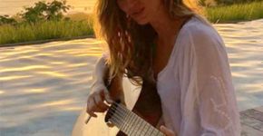 Gisele Bündchen toca violão ao pôr do sol em cenário paradisíaco