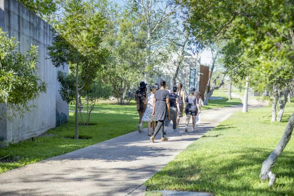 Jardim, aberto para a savana, une complexo do lodge com vilas, loja, galeria de arte, academia e salão de beleza