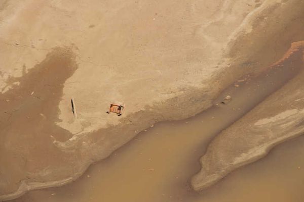 Os 34 milhões de metros cúbicos de rejeitos lançados no meio ambiente pela Samarco* deixaram um rastro de destruição por onde passaram. A cadeira tombada à beira do rio é o retrato de que nada ficou no lugar após a passagem da lama. *Segundo laudo técnico do Ibama publicado em novembro de 2015