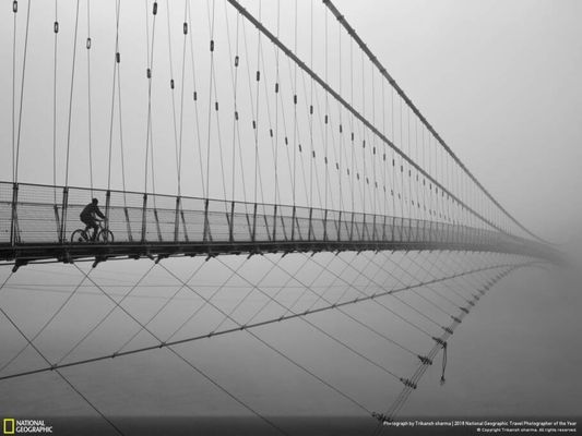 Ciclista cruza ponte Ram Jhula em Rishikesh, na Índia; imagem foi a mais votada pelo público na categoria Cidades
