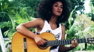 A cantora cresceu ouvindo rap e samba de raiz e aprendeu a tocar violão em meio a artistas da MPB. Resultado: uma cantora que toca rap no violão