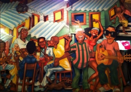 Mas paredes, ilustrações que retratam animadas reuniões em nome do samba.