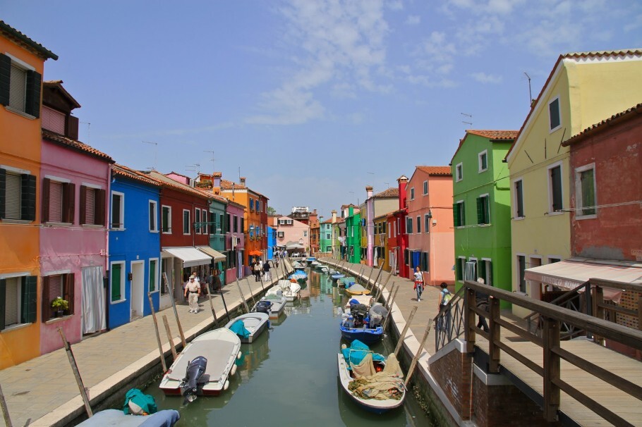 Isola di Burano é famosa por suas casas coloridas e pela fabricação de rendas; é ligada à Veneza por uma ponte