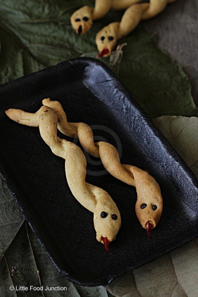 Espetos de pão em formato de cobra com pimenta e pimentões.