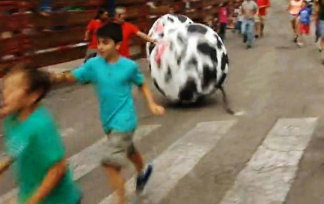 Crianças correm de bola gigante pintada de touro