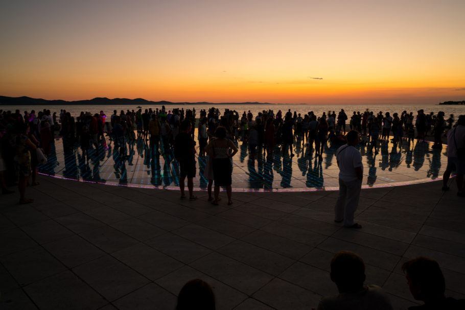Turistas apreciam o pôr do sol em cima do o Nikola Basic’s Sea Organ