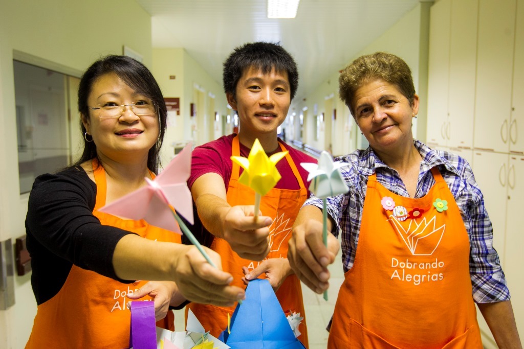Voluntários do Projeto Dobrando Alegrias, em que as pessoas visitam hospitais e ensinam pacientes e familiares a fazer origami