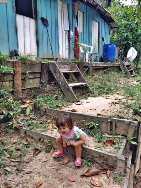 Pequena viajante explorando uma comunidade ribeirinha – Amazônia.