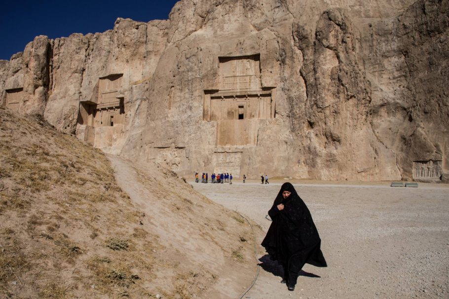 Mulher de chador caminha pelas “Royal Tombs” dos antigos persas, próximo à Persépolis