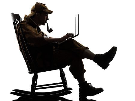 sherlock holmes with computer laptop silhouette sitting in rocki