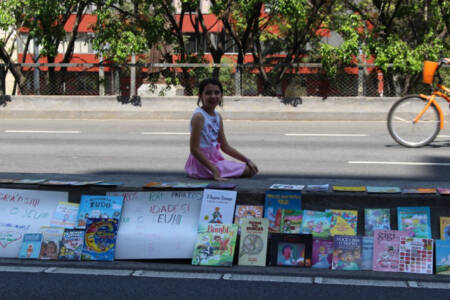 Giovana, de 9 anos, e os livros expostos no Minhocão para serem doados
