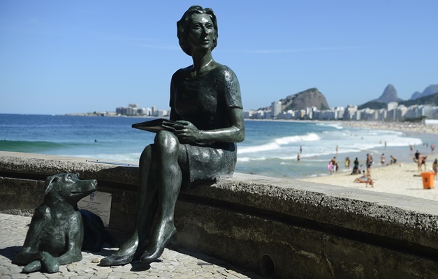 Clarice Lispector está ao lado de seu cachorro na Praia do Leme