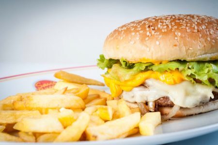 Os hambúrgueres podem vir acompanhados de batatas fritas ou onion rings – porção de anéis de cebola empanados e fritos